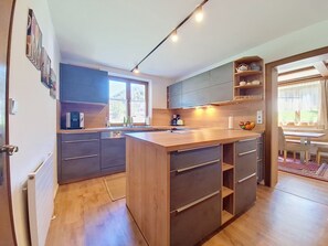 Eine moderne Küche mit Kochinsel, integrierten Geräten und Blick zum Essbereich.