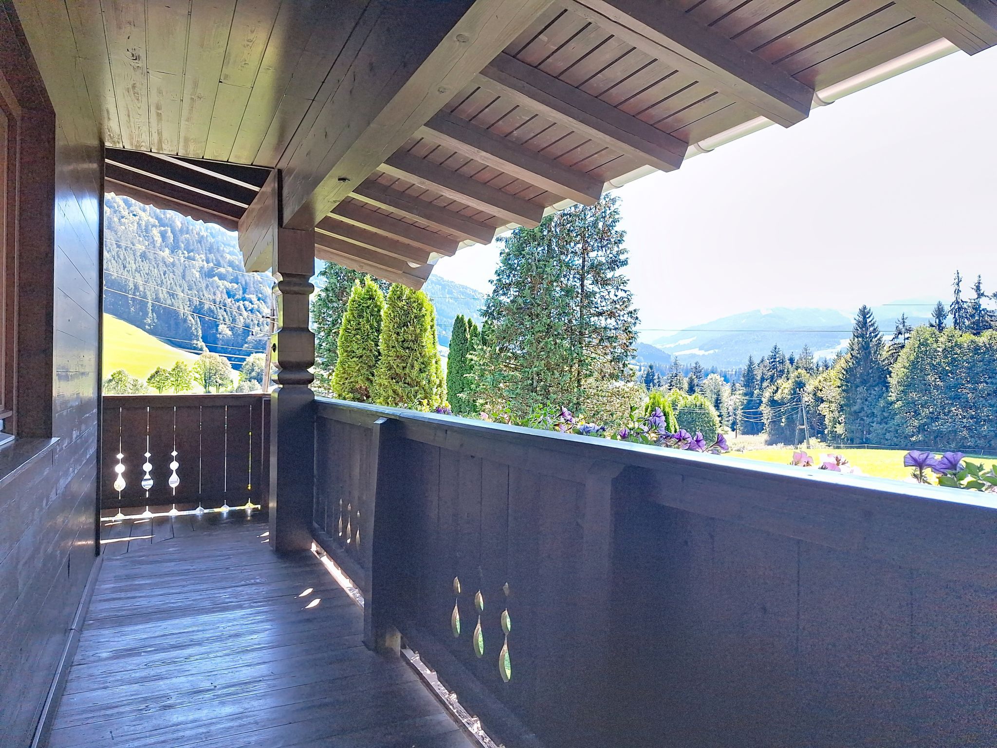 A wooden balcony with a view of a mountainous landscape.