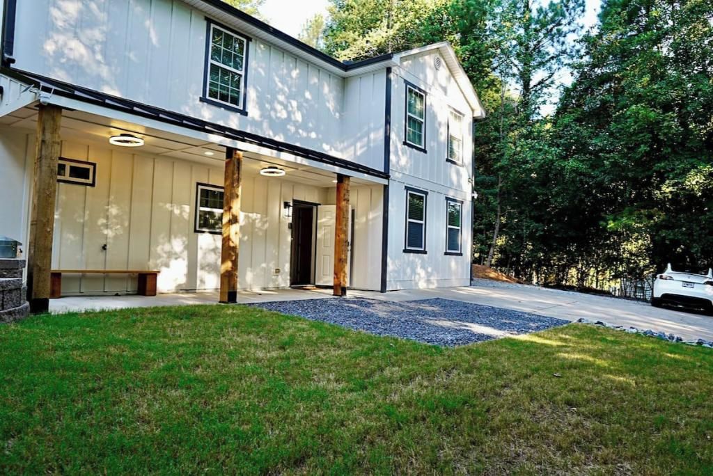 A two-story house with a covered porch, a garage, and a driveway.
