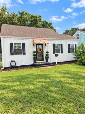 A single-story house with a front porch, a door with a wreath, and a mailbox. - Cozy 2-bedroom house in beautiful Morehead City (Morehead City)