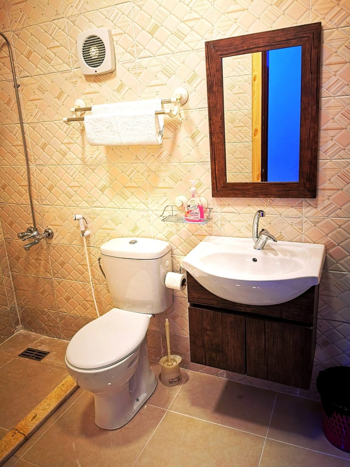 Casa de banho com sanita, lavatório e espelho.