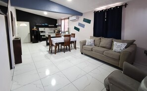 A living room with a sofa and a dining table set for four. - Casa Tabor, Lereto Center (Loreto)