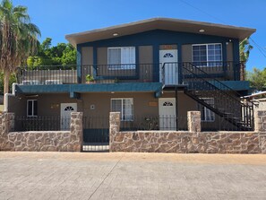 A two-story building with a stone facade, multiple windows, and a balcony. - Casa Tabor, Lereto Center (Loreto)
