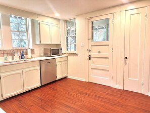 A kitchen with white cabinets, a microwave, and a dishwasher. - The Cobblestone Estate - Historic Downtown Ocala! (Ocala)