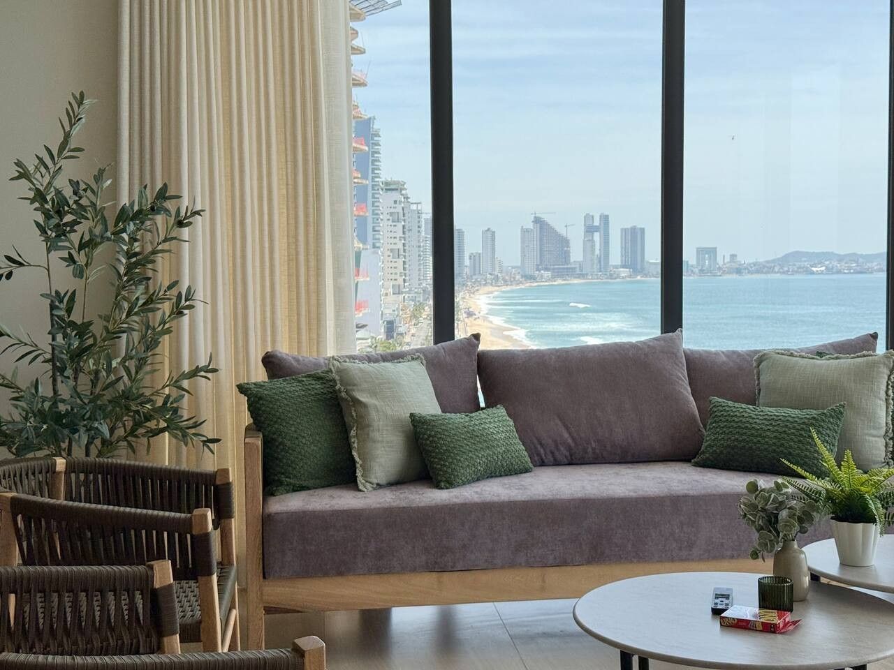 Uma sala de estar moderna com vista para o oceano e o horizonte da cidade.