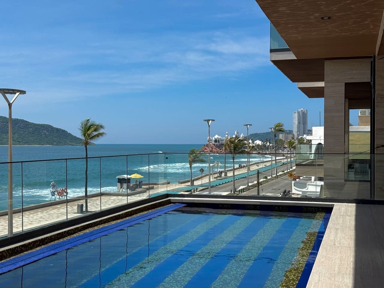 Piscina com vista para a praia e o oceano.