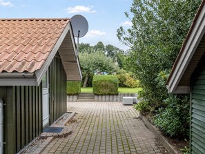 A residential property with a paved driveway, satellite dish, and a well-maintained garden. - "Dior" - 800m from the sea by Interhome (Hejls)