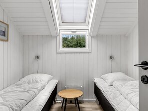 A compact room with two beds, a skylight, and a small table. - "Dior" - 800m from the sea by Interhome (Hejls)
