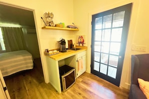 A compact kitchen with a built-in microwave, coffee maker, and a small sink. - Bourbon & Lace Retreat (Texanna)