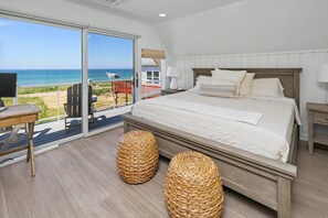 Une chambre dotée d’un grand lit, d’une télévision et d’un balcon offrant une vue sur l’océan.