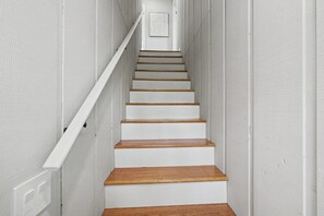 Eine weiße Treppe mit hölzernen Stufen und einem weißen Geländer.