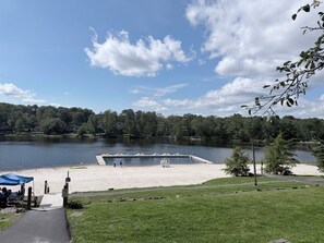 Un parque junto al lago con una playa de arena, una torre de salvavidas y un cielo despejado.