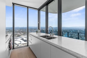 A modern kitchen with a large window and a city view. - Luxury 2BR Broadbeach Island Escape (Broadbeach)