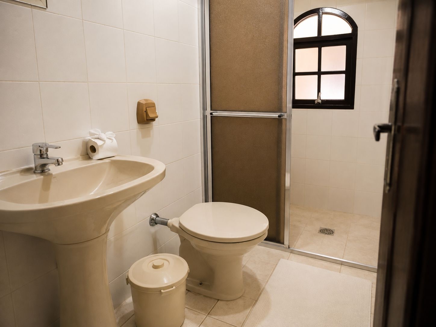 Un baño con lavamanos, inodoro y zona de ducha.