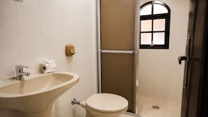 Une salle de bain équipée d’un lavabo, de toilettes et d’un espace douche.