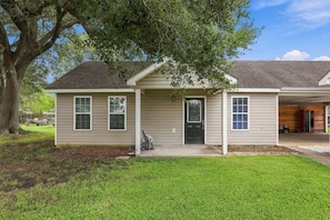 A single-story house with a front porch, a garage, and a tree in the yard. - Cozy Mid-City 1BR Home Near Casinos (Lake Charles)