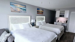 A hotel room with two beds, a kitchenette, and artwork on the walls. - New updated Daytona Oceanview w/kitchenette, pool (Daytona Beach)