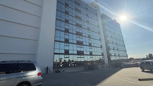 A modern building with a glass facade and a parking lot in front. - New updated Daytona Oceanview w/kitchenette, pool (Daytona Beach)