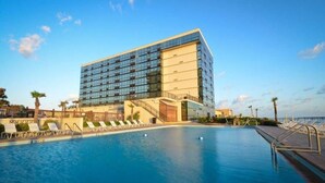 Um hotel moderno com uma piscina grande e espreguiçadeiras.