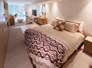 A modern bedroom with a large bed, a bedside table, a mirror, and a view of the outdoors. - Luxury Studio Bondi Beach Front (Bondi Beach)