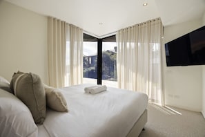 Habitación de hotel con una cama grande, un televisor de pantalla plana y vistas al exterior.