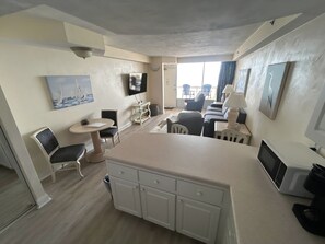 A compact hotel room with a kitchenette, a dining area, a sofa, and a TV. - Spacious 1bdrm direct oceanfront w/private balcony (Daytona Beach)