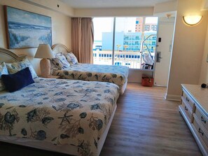 A hotel room with two beds, a view of the city, and a balcony. - Spacious 1bdrm direct oceanfront w/private balcony (Daytona Beach)