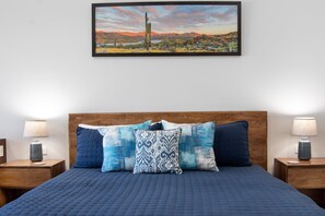 A bedroom with a bed, two bedside tables, and a painting on the wall. - One 503B Studio: Vista del Sol Studio (Puerto Peñasco)
