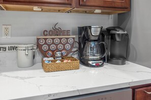 Un comptoir de cuisine avec une machine à café, un moulin à café et un objet décoratif sur le thème du café.