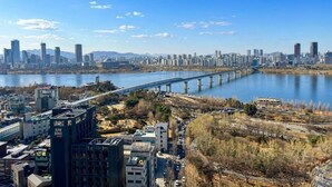 Un paisaje urbano con un río, un puente y rascacielos.