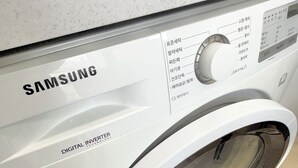 Una lavadora Samsung Digital Inverter con panel de control y puerta transparente.