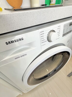 Eine Samsung Digital Inverter Waschmaschine mit Bedienfeld und Glastür.