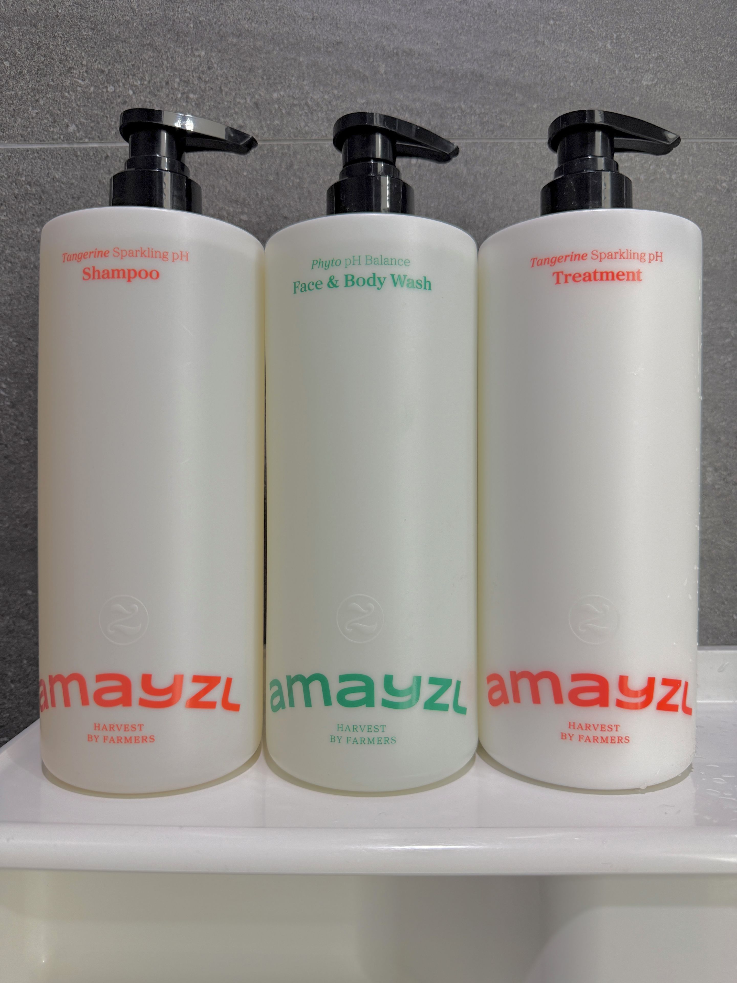 Three bottles of Amayzl products on a white shelf.