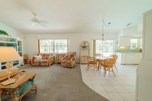 A spacious living area with a dining table, chairs, a sofa, and a ceiling fan. - Waterfront heated pool home near beaches. 2 bedroom suites! (Port Charlotte)