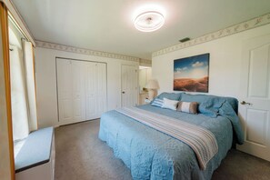 A bedroom with a large bed, a nightstand, a lamp, and a painting on the wall. - Waterfront heated pool home near beaches. 2 bedroom suites! (Port Charlotte)