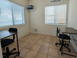 A room with two desks, chairs, and a window with blinds. - Charming 2BR Tucson Home – Minutes to U of A & Downtown! (Tucson)