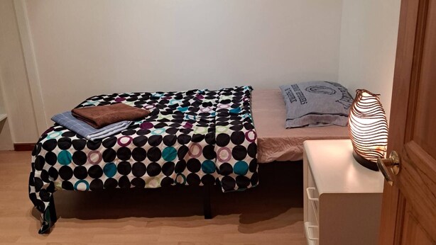 A small bedroom with a bed, a bedside table, and a lamp. - Room-pretty Room -shared Accommodation (Coquitlam)