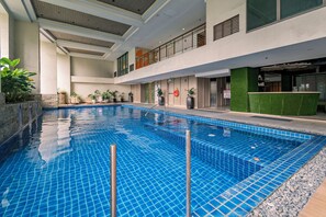 An indoor swimming pool with tiled walls and a clear blue water surface. - Tropical Retreat • 24F Balcony • Sauna • Gym • Greenbelt • Makati (Makati)