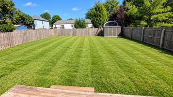 A well-maintained backyard with a wooden deck, a shed, and a wooden fence.