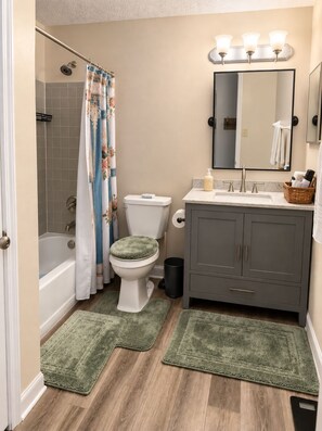 A bathroom with a bathtub, toilet, vanity, and a shower curtain. - Furnished 3BR Home Near Columbus / Families, Business & Extended Stays (Pickerington)