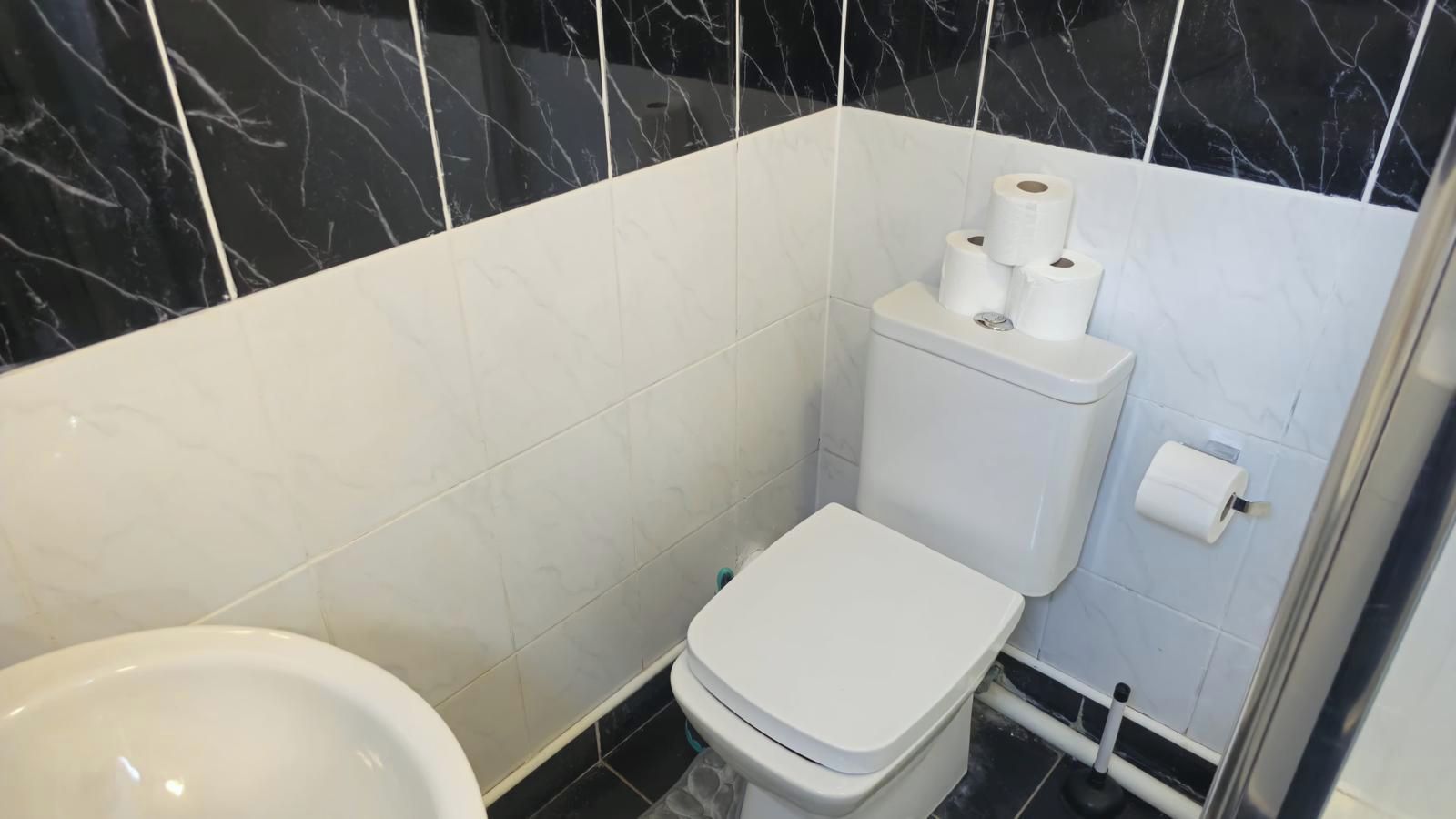 A bathroom with a toilet, bidet, and a shower area.