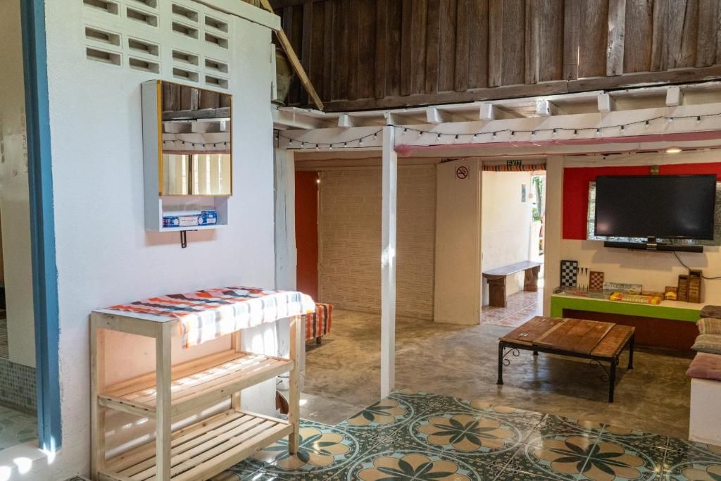 A room with a wooden bench, a television mounted on the wall, and a patterned floor.