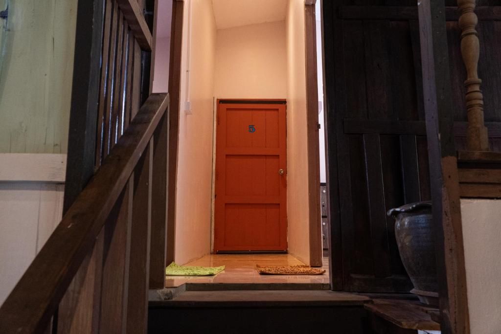 Una escalera de madera que lleva a una puerta cerrada con el número 5.