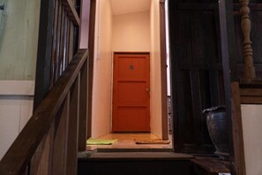 Una escalera de madera que lleva a una puerta cerrada con el número 5.