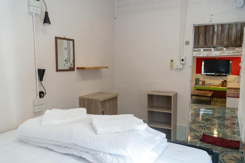 Et hotelværelse med seng, skrivebord, fjernsyn og et badeværelse, der kan ses gennem en åben dør.