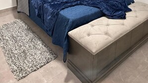 A bedroom with a bed, a bedside table, a rug, and a window. - Cozy 2-bedroom bungalow with AC in charming Runaway Bay. Hosts up to 4  persons. (Runaway Bay)