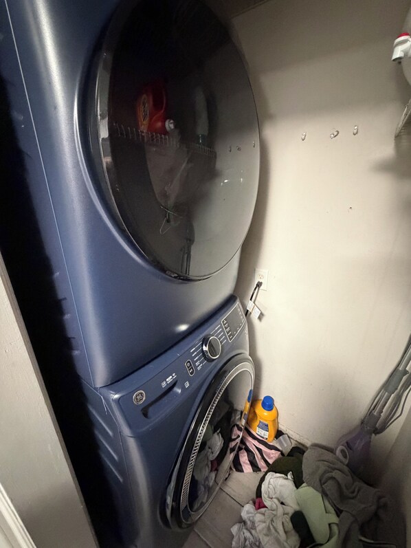 A front view of a washing machine with a control panel, a door, and a basket.
