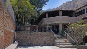 A courtyard with a swimming pool, a brick wall, and a building with a balcony. - Escápa de la realidad, casita en el cerro campestre con el mejor clima! (Tepic)
