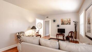 A living room with a sofa, a lamp, a TV, and decorative items.