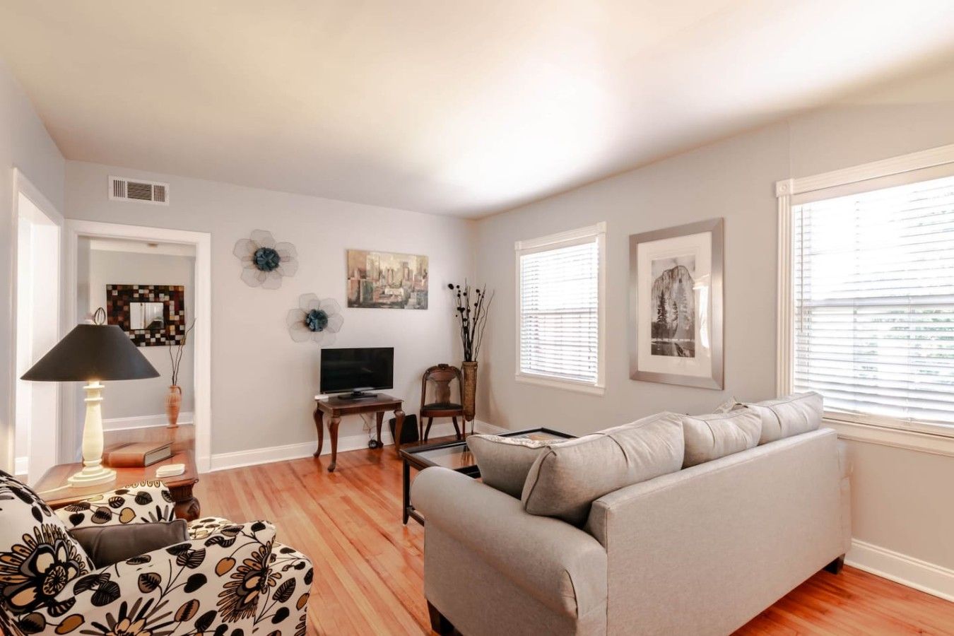 A living room with a sofa, TV, and artwork on the wall.
